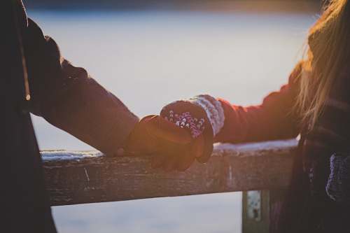 holding hands On a winter's day, young lovers hands touch on a cabin railing love